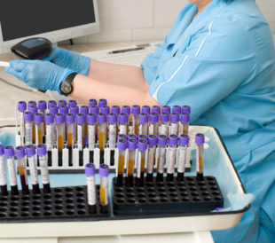 Nurse feeds data of test tubes with blood for analysis into the database. Image: withGod/Shutterstock.com.
