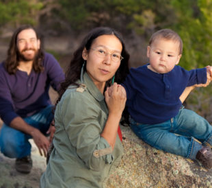 Young multicultural family in nature - shallow DOF - focus on mother & baby. Image: Mona Makela/Shutterstock.com.
